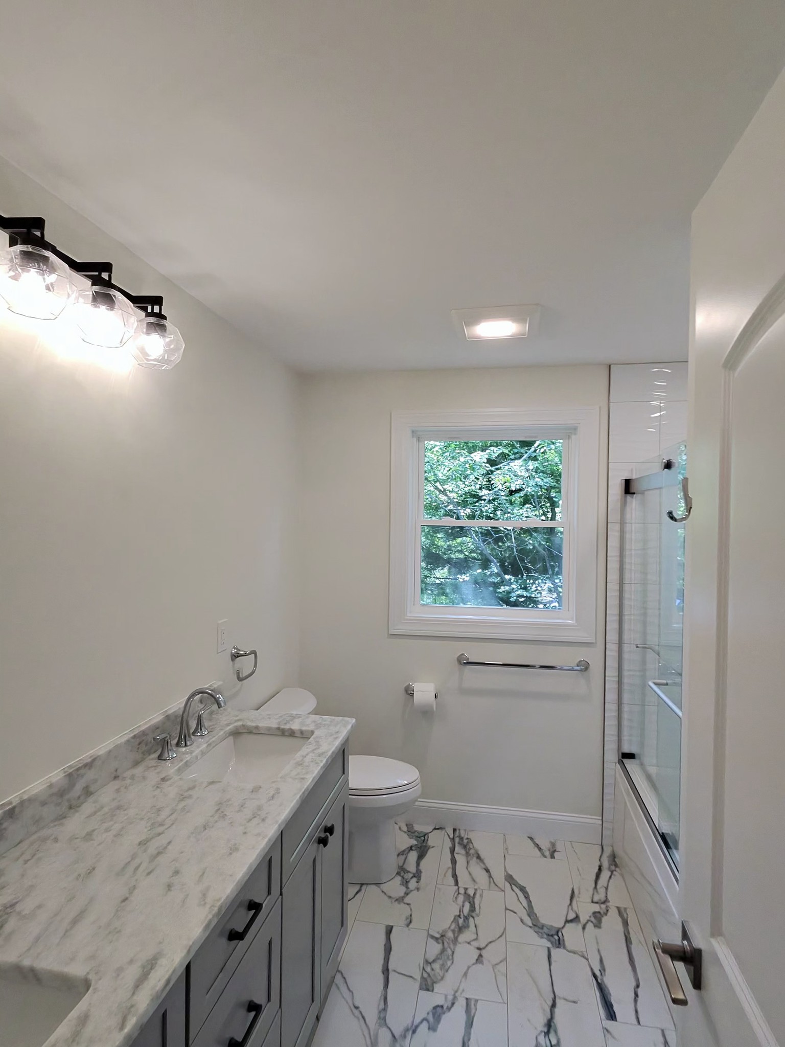 Main bath with double vanity and marble-look porcelain tile floor