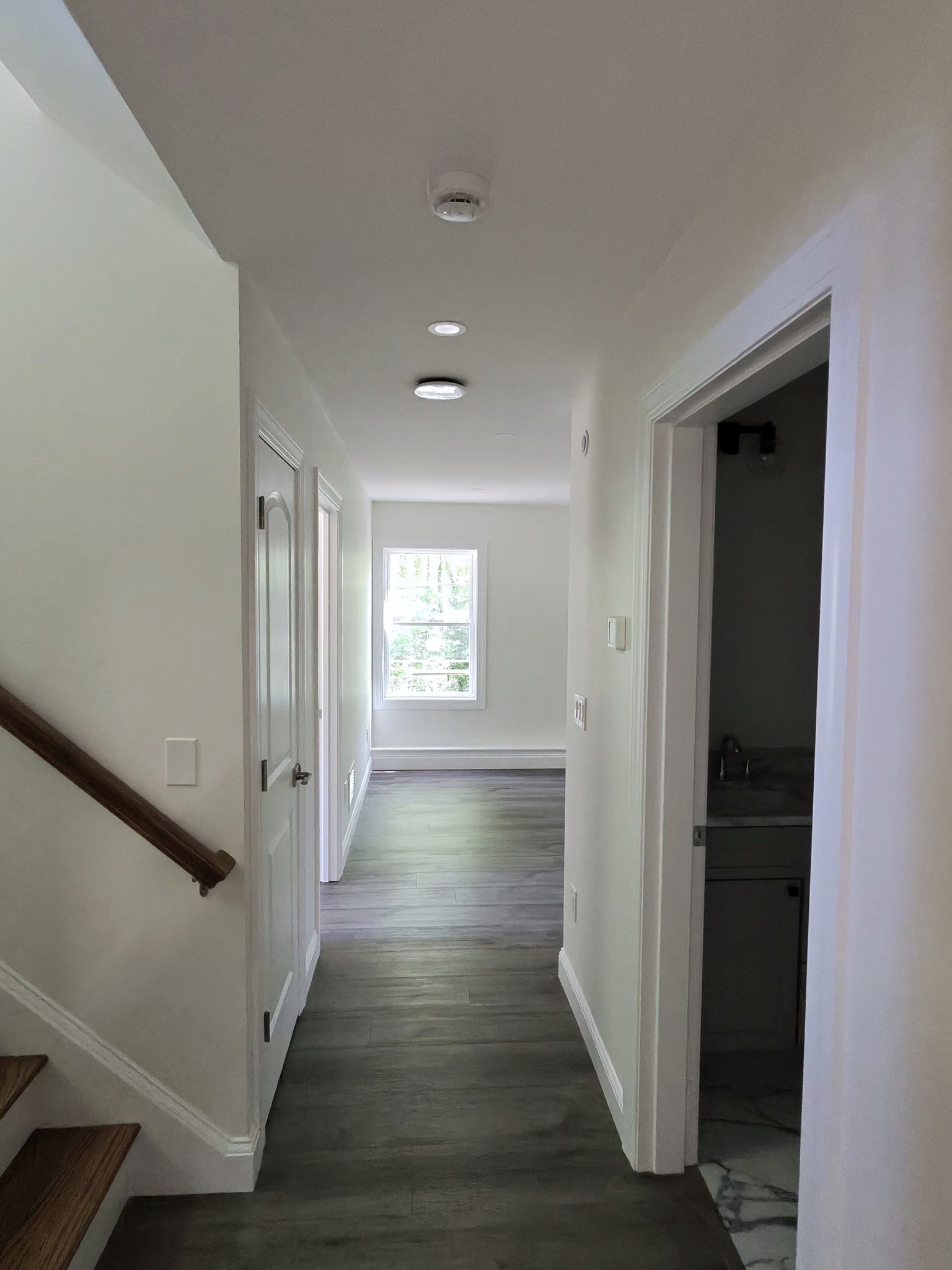 Upper hallway with red oak stair rail and luxury vinyl plank flooring